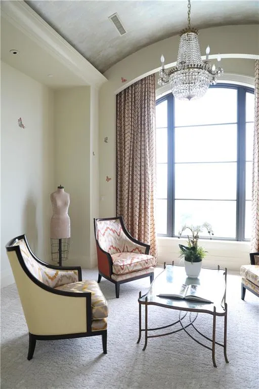 Living area featuring a notable chandelier and carpet floors