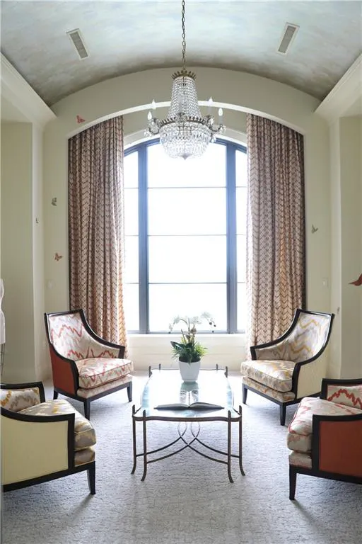 Unfurnished room featuring a notable chandelier, vaulted ceiling, and a wealth of natural light