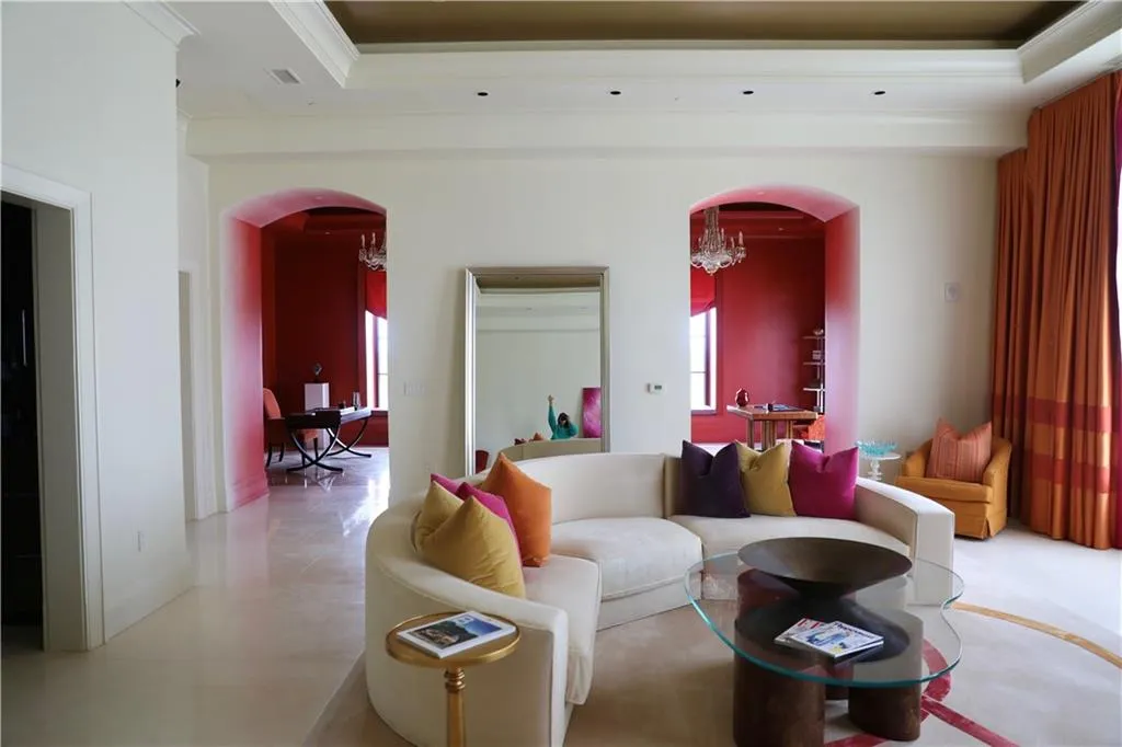 Living room with ornamental molding and an inviting chandelier