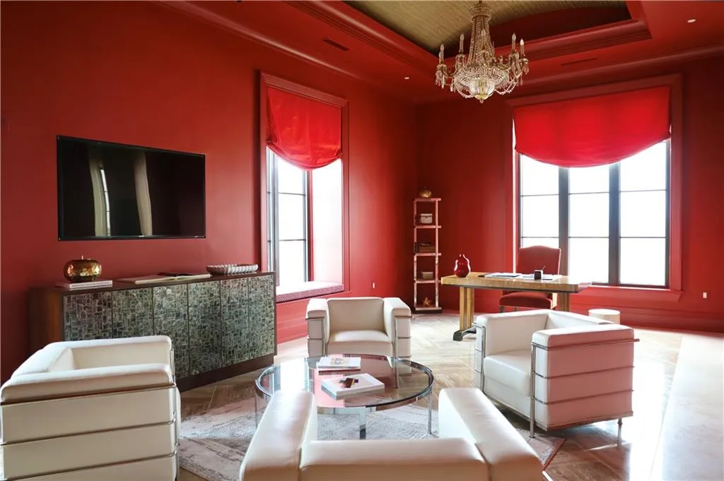Living room with an inviting chandelier, parquet flooring, a raised ceiling, and crown molding