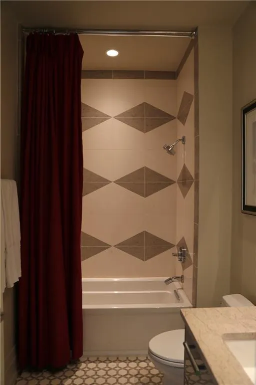 Full bathroom featuring shower / bath combo, vanity, and toilet