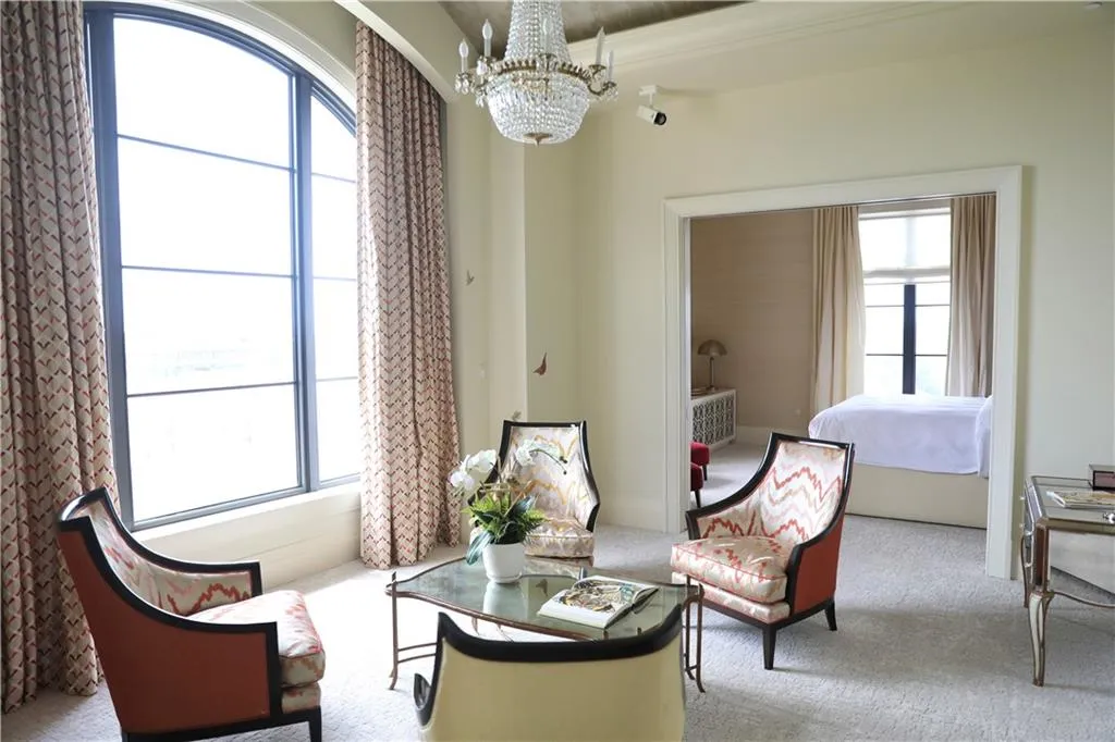 Living area featuring a chandelier, light colored carpet, and plenty of natural light