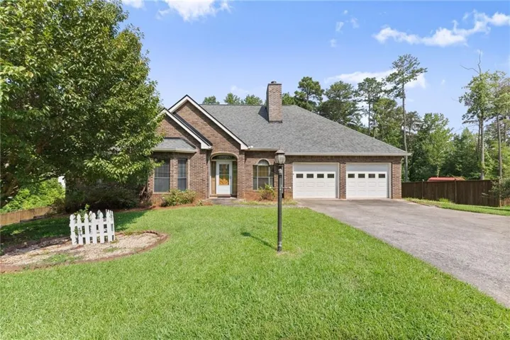 Brick exterior with a gabled roofline, featuring a two-car garage with individual doors