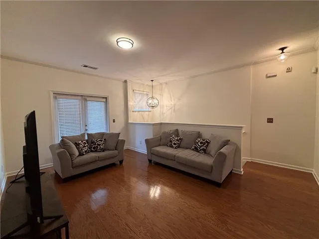 Spacious room featuring wood-finish flooring, white trim, and light wall tones