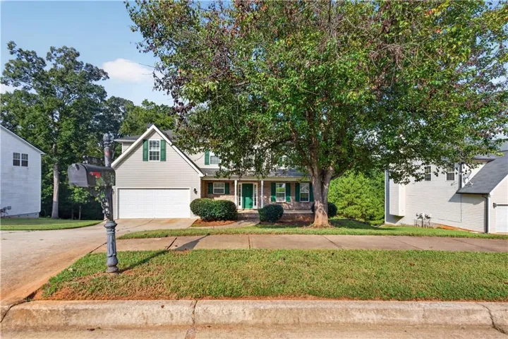 Two-story residence with light gray siding, white trim, and green shutters