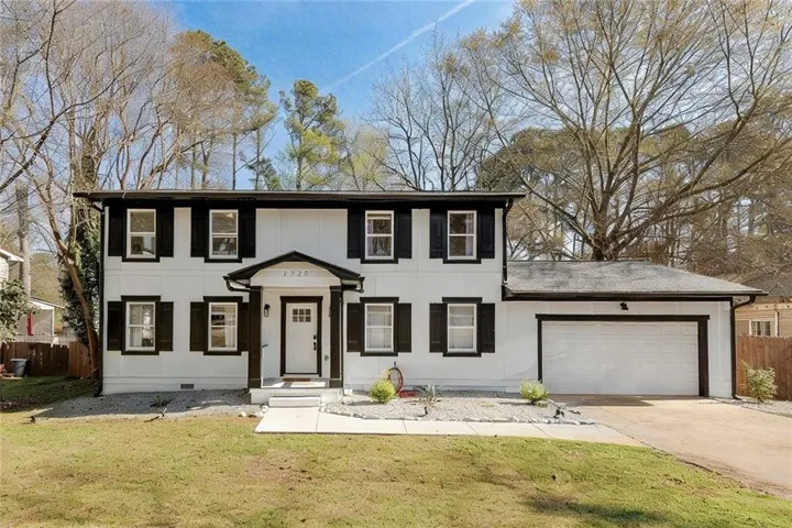 Charming two-story home on a spacious, tree-lined lot with a two-car garage.