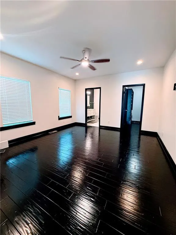 Empty room featuring baseboards, hardwood / wood-style floors, ceiling fan, and recessed lighting
