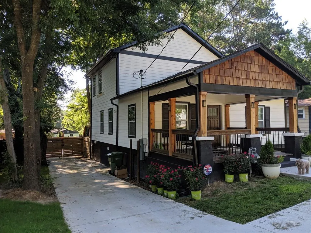 View of front facade featuring a garage, driveway, and covered porch