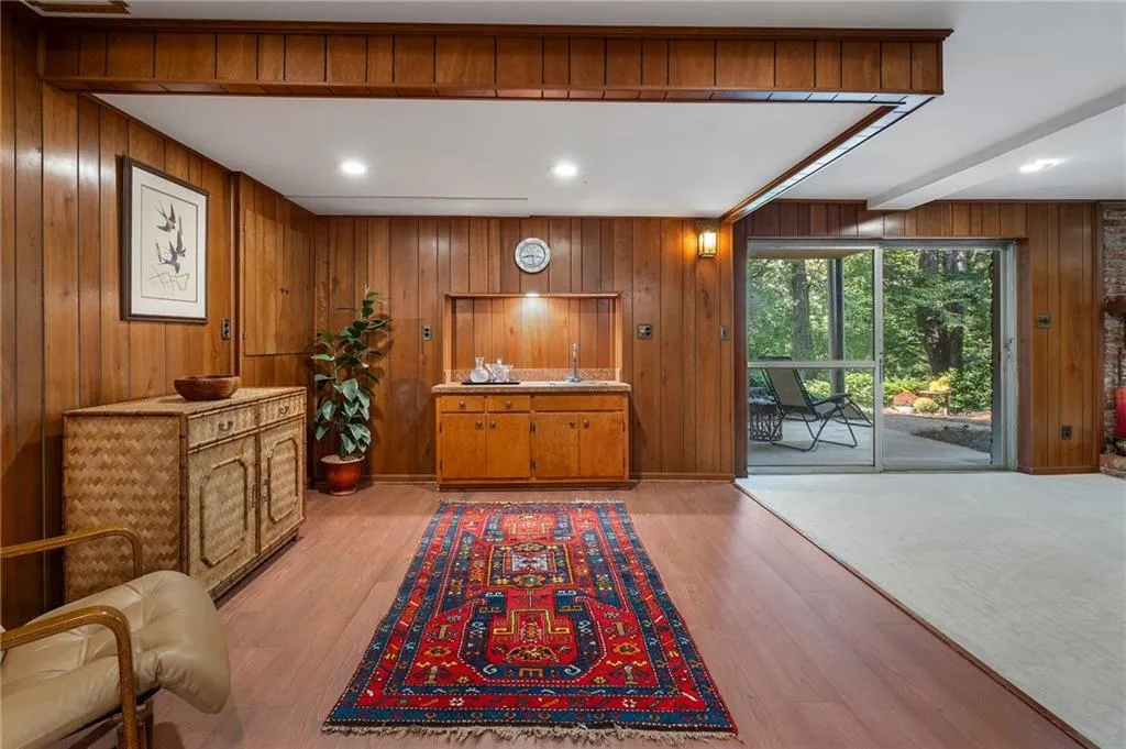 Sitting room featuring wood walls, sink, and light hardwood / wood-style flooring