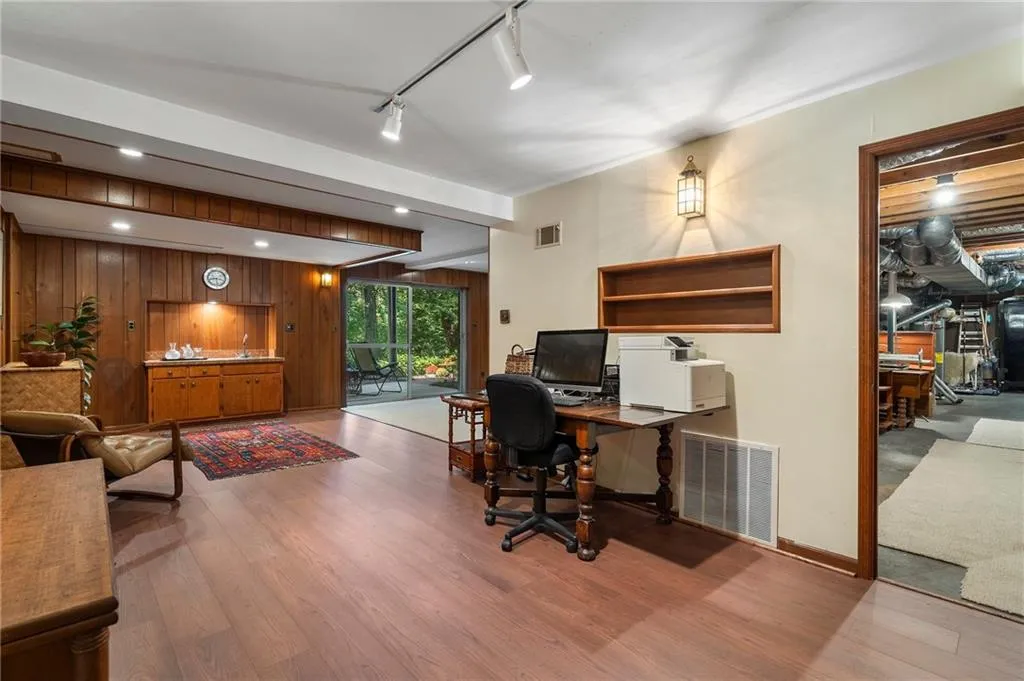 Office area featuring light wood-type flooring and wood walls