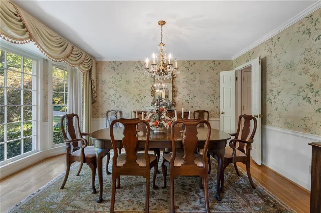 Dining space with a notable chandelier, ornamental molding, and hardwood / wood-style flooring