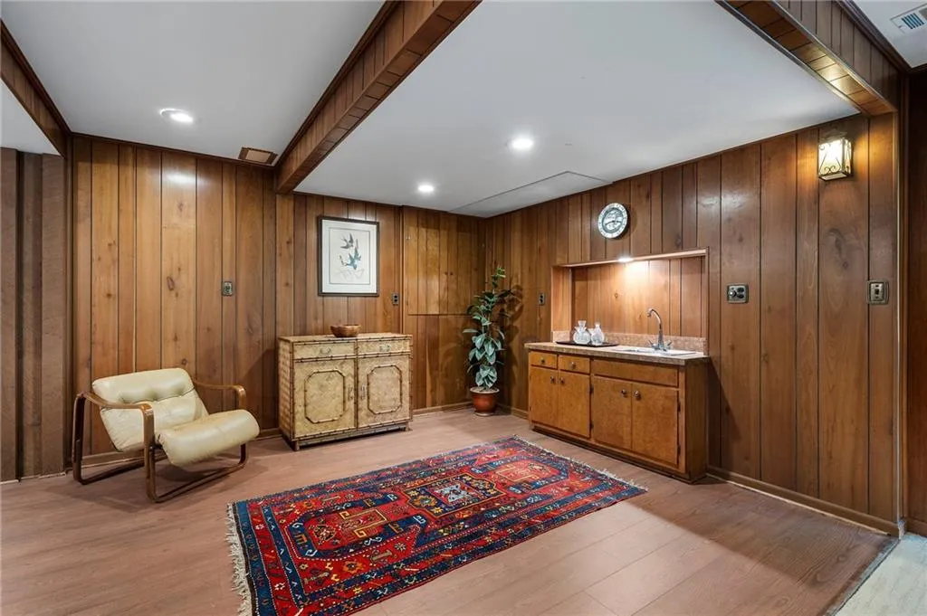 Sitting room featuring wood walls, sink, and light hardwood / wood-style flooring
