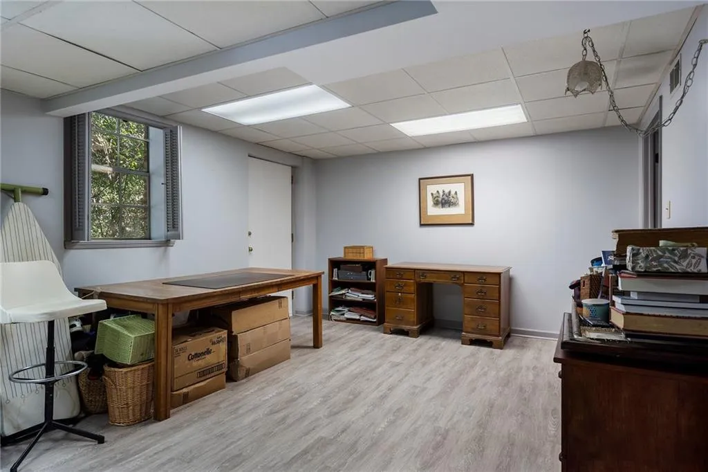 Office area featuring light wood-type flooring and a paneled ceiling
