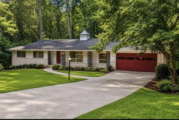 Ranch-style residence featuring a prominent red garage door and a complementary red front door
