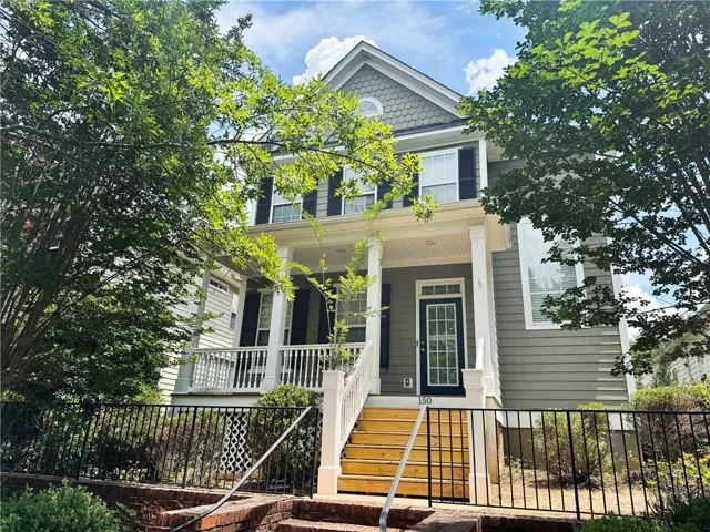 Two-story residence featuring a covered front porch with white columns, painted siding, and black shutters