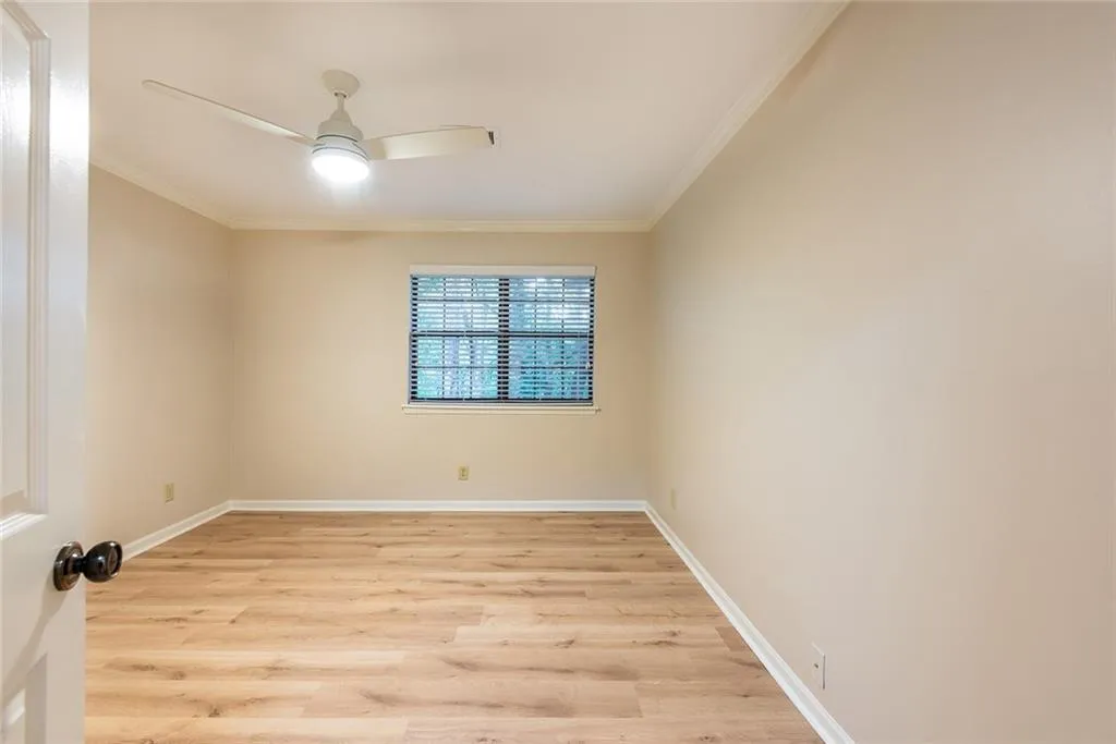 Bedroom with ceiling fan, light wood-type flooring, and crown molding