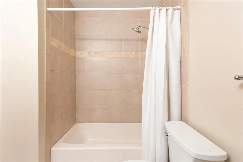 Bathroom featuring shower / tub combo and toilet