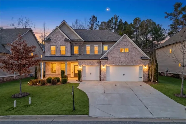 Brick and siding facade, two-car garage, covered entry, landscaped front yard, and concrete driveway