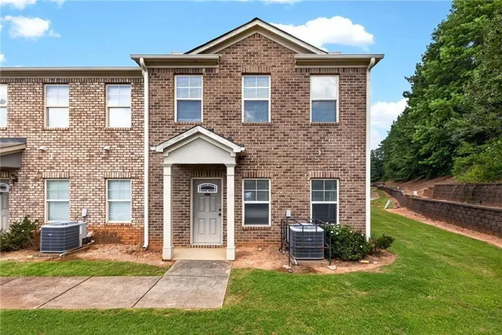 Brick-faced exterior featuring a covered front entry with white columns