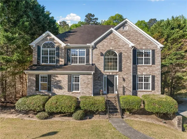 View of front of property with brick siding and a front lawn