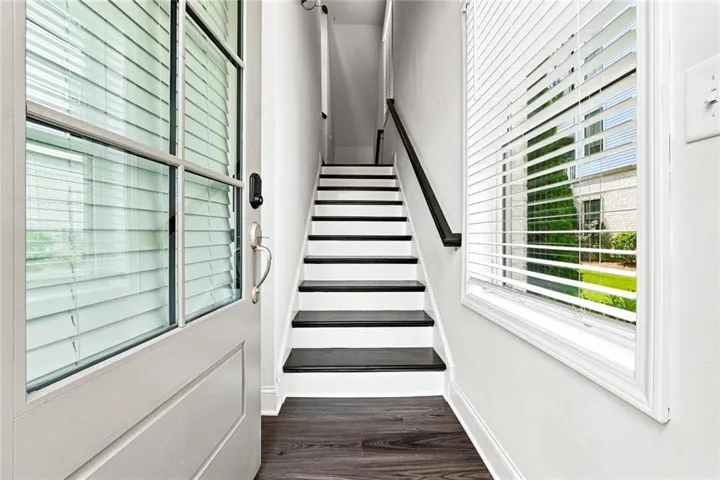 Three-story facade featuring white brick, horizontal siding, and grey paneling