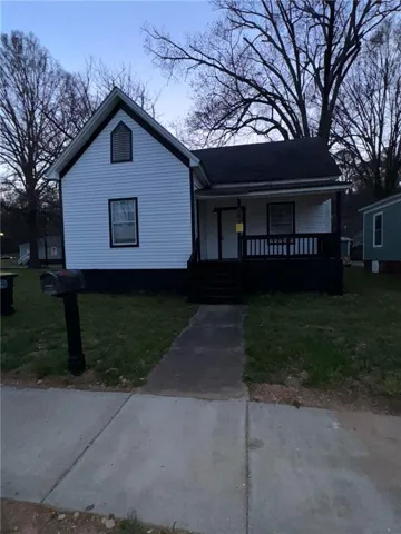 White siding exterior with dark trim and a gabled roofline