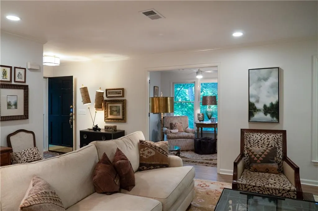 Living room with light wood-type flooring,   crown molding, recessed lighting on dimmers