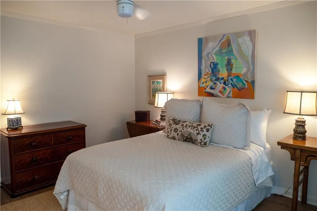 Bedroom with ceiling fan, hardwood / wood-style flooring, and crown molding