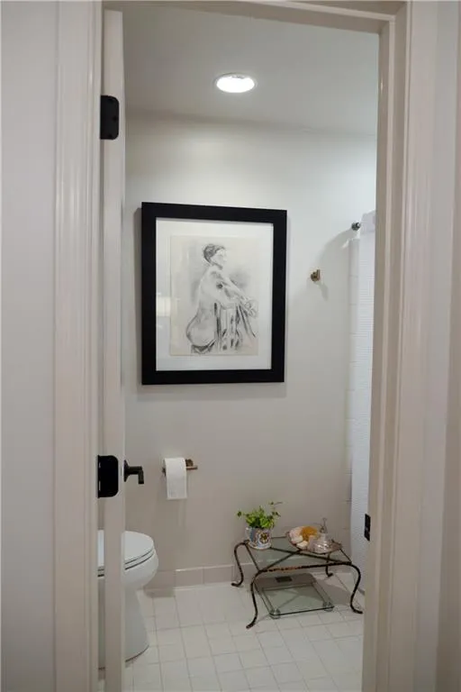 Bathroom with NEW toilet, tile patterned floors, and tub/shower combo.