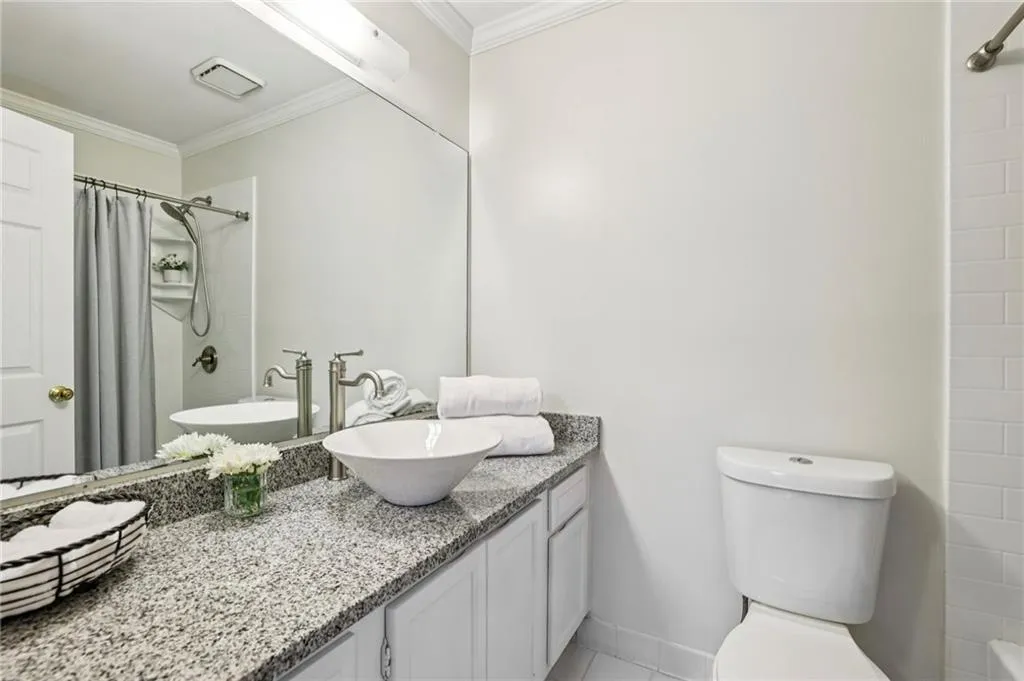 Secondary bathroom ensuite with ample countertop space and a shower/tub combination.