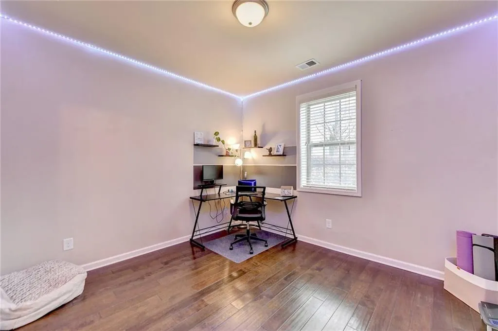 Home office with dark hardwood / wood-style floors