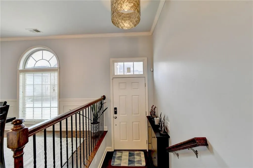 Entryway with ornamental molding and dark hardwood / wood-style flooring