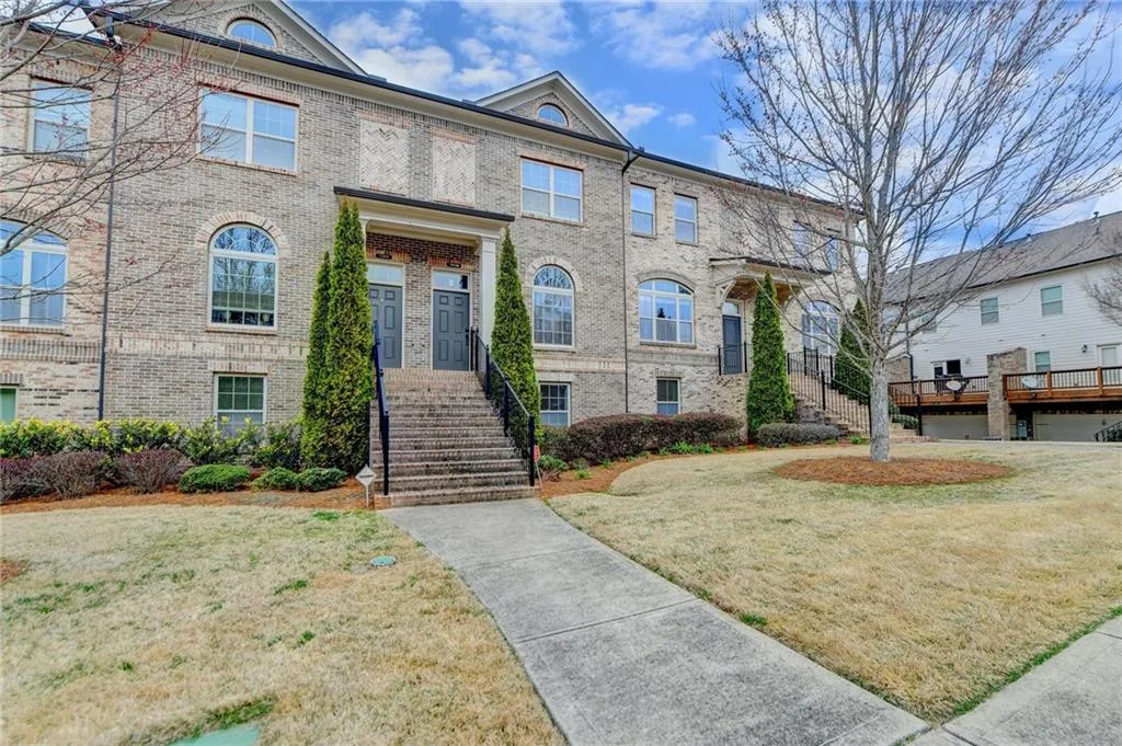 Townhome / multi-family property with a front lawn