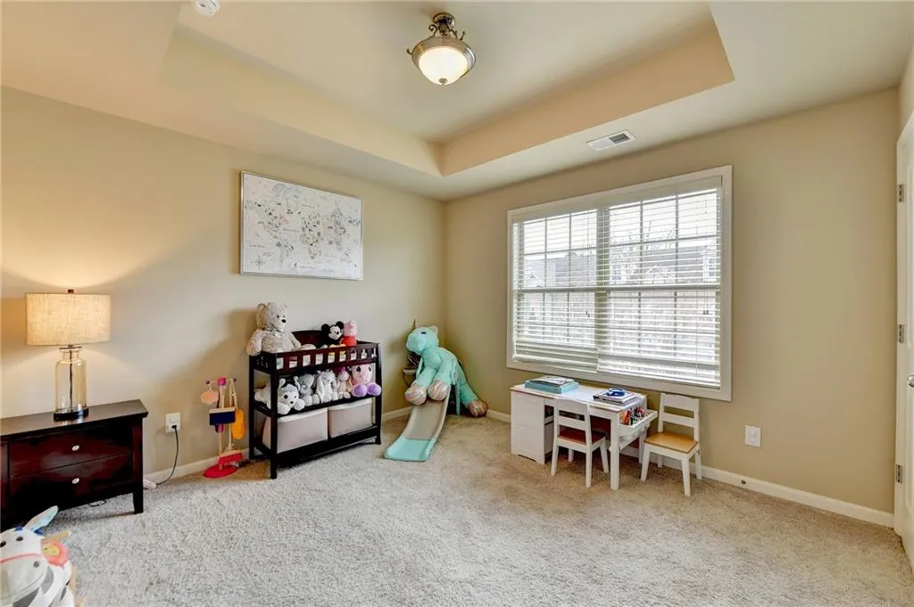 Recreation room featuring light colored carpet and a raised ceiling
