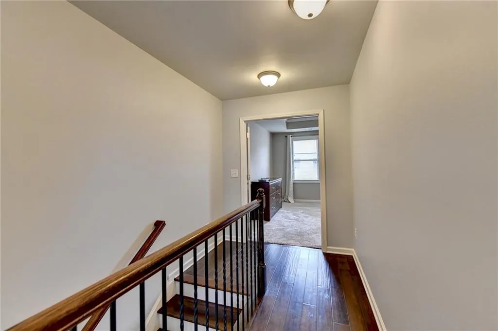 Hallway with dark hardwood / wood-style flooring