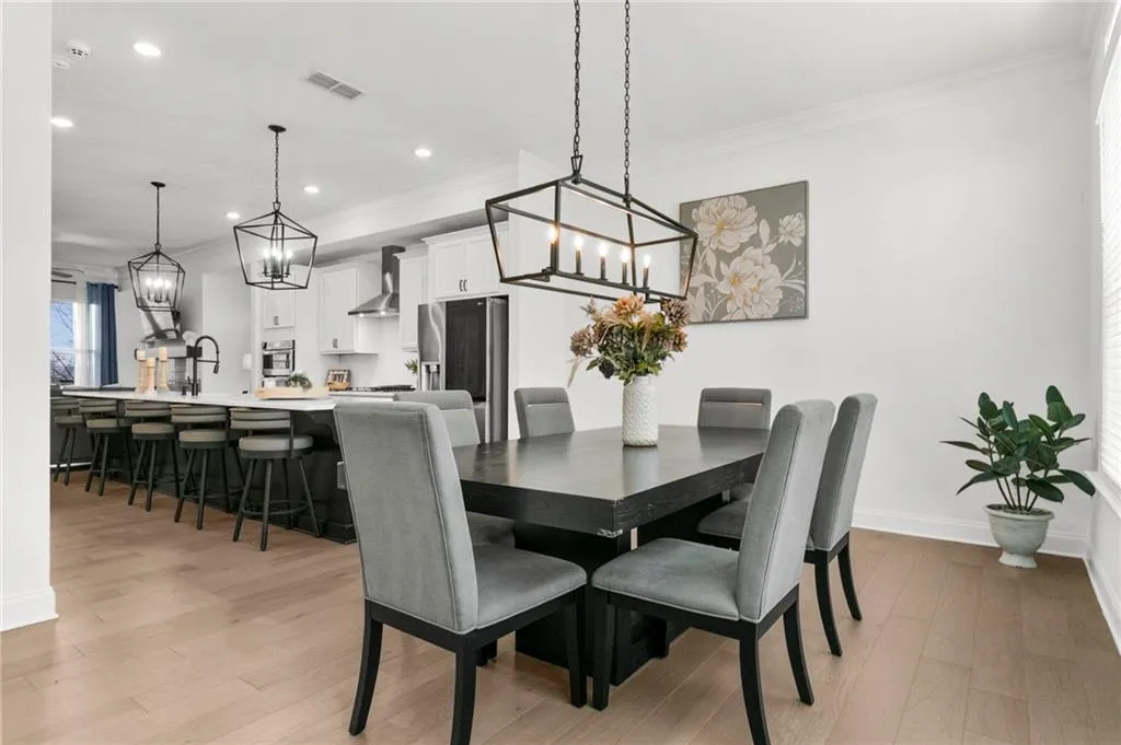 Dining space with a chandelier, light wood finished floors, and crown molding