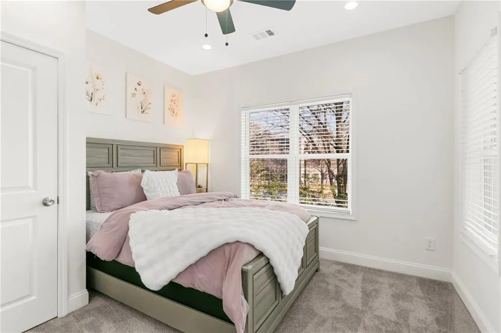 Bedroom with light carpet, ceiling fan, and recessed lighting