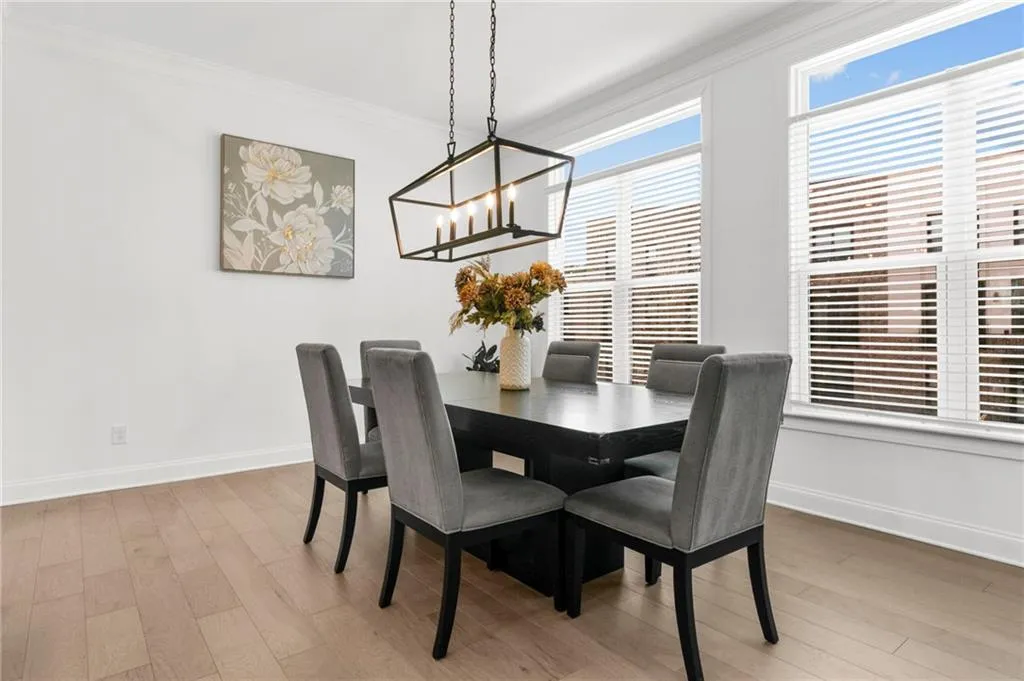 Dining room with crown molding, light wood-style floors, and a chandelier