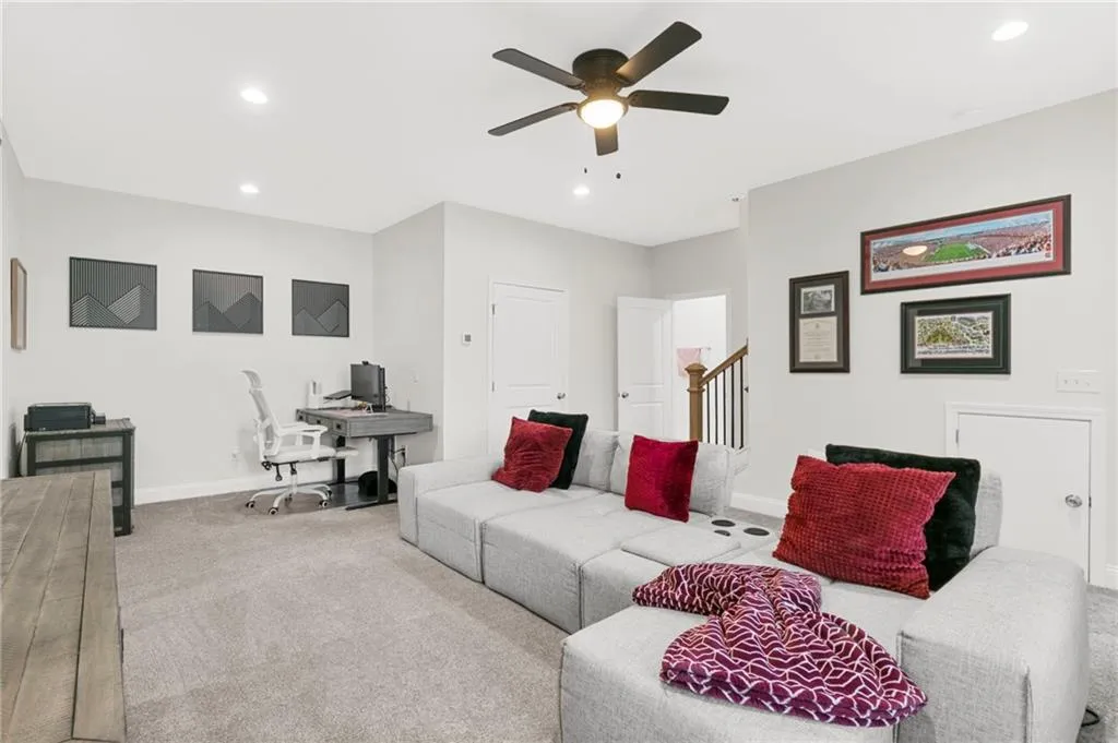 Carpeted living area with a desk, recessed lighting, and a ceiling fan