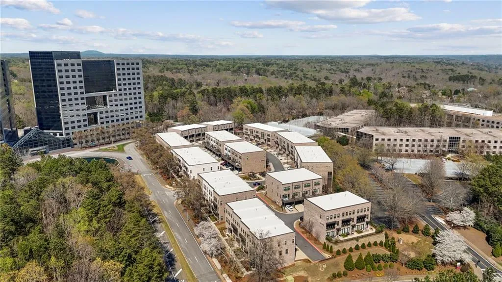 Aerial view of a heavily wooded area and apartment complex / building