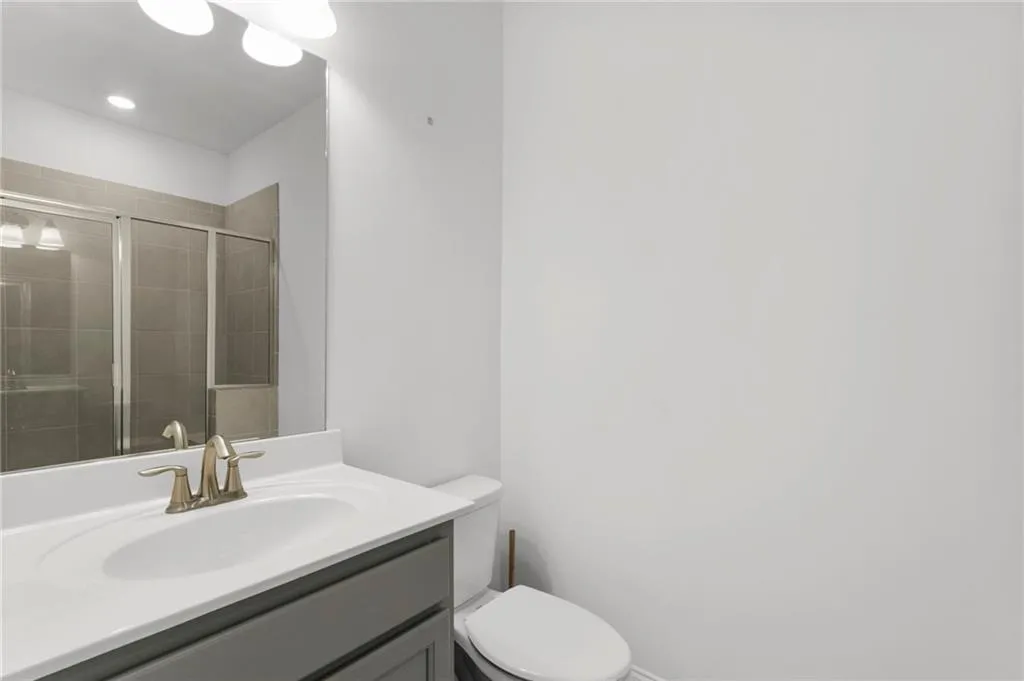 Full bathroom with vanity and a shower stall