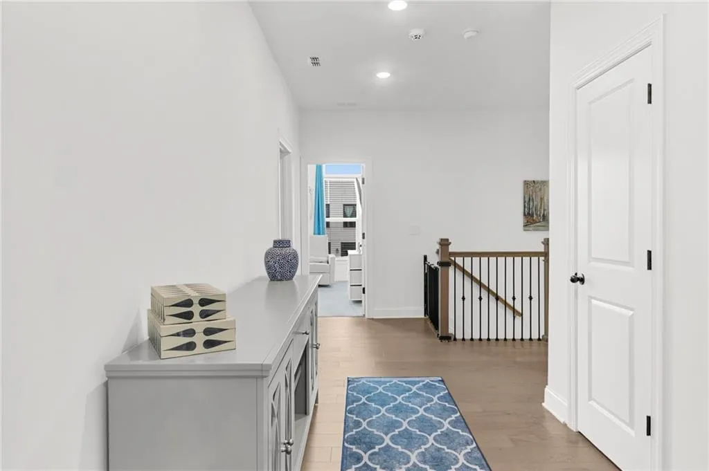 Corridor featuring an upstairs landing, light wood-type flooring, and recessed lighting