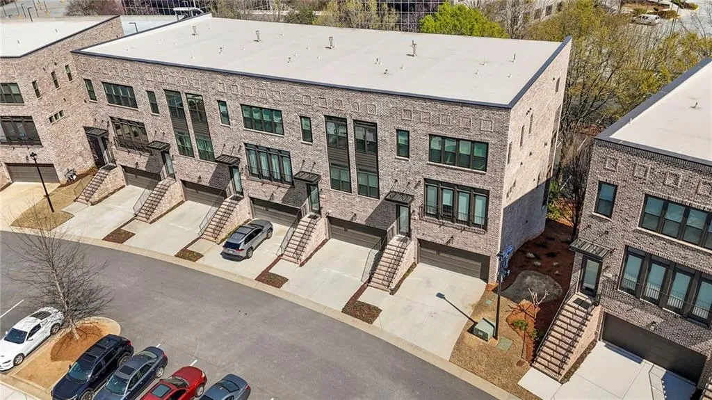 View of apartment building / complex featuring an attached garage and driveway
