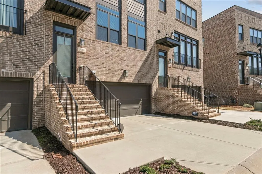 Property entrance featuring a garage, brick siding, and concrete driveway