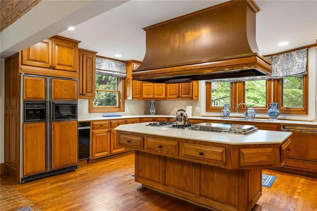 Custom copper vent hood accents the large island with cooktop and griddle