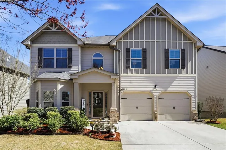 Craftsman house with a garage, concrete driveway, board and batten siding, and stone siding