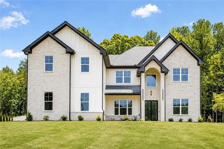 Contemporary farmhouse-style exterior featuring a light brick facade and vertical white siding