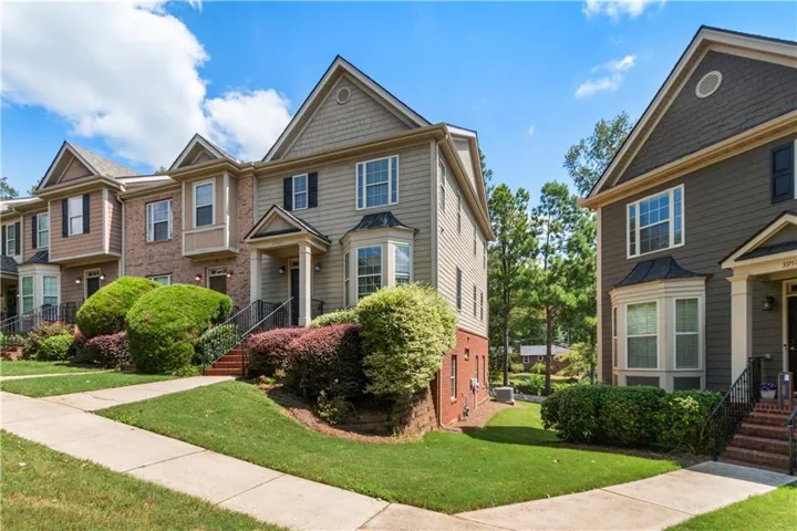 Multi-level townhome featuring a bay window, covered entry, and brick and siding exterior