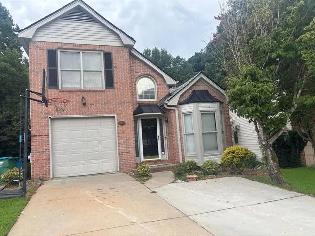 Brick exterior with gabled roofline and front-facing garage