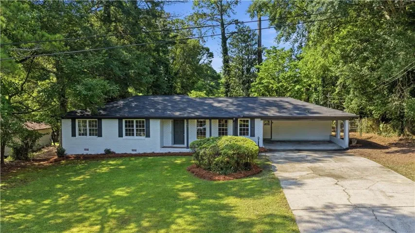 Ranch-style residence featuring a dark shingle roof, white exterior siding, and dark window shutters